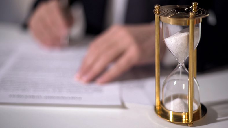 Stephen C. Carter, PC Attorney at Law | Hartwell, GA | closeup of sand clock measuring time as signing important documents